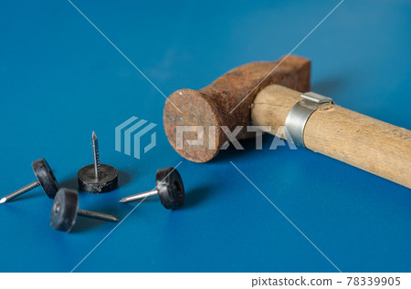 Old hammer and nails on a blue background. Old hammer and nails on a blue background. 78339905