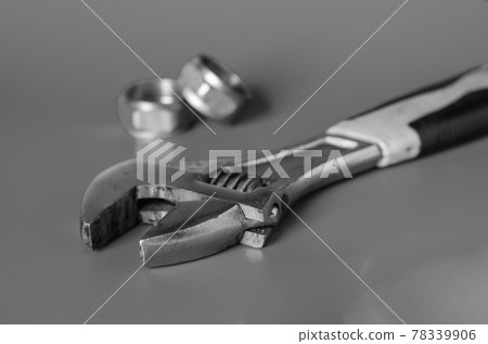Used Adjustable Wrench and Two Nuts on a gray background. Used Adjustable Wrench and Two Nuts on a gray background. 78339906