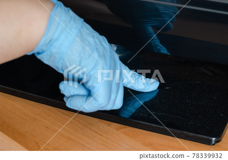 A hand in a blue glove points to the dirt on the stand. 78339932