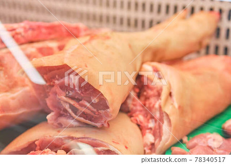 Slice of raw pig leg meat on the counter. 78340517