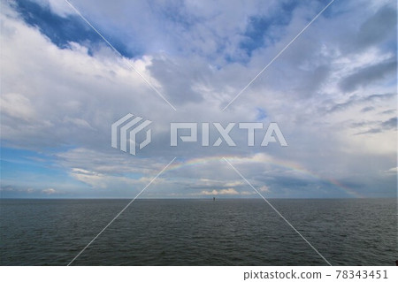 Rainbow above the north sea against a blue sky with clouds Rainbow above the north sea against a blue sky with clouds 78343451