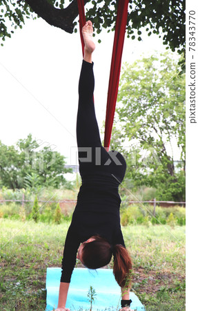 The girl is engaged in fly yoga in nature. Hammock suspended from a tree. Relax meditation 78343770