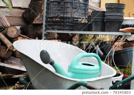Gardening equipment: cart, watering can, crates, fertilizers and flowers 78345803