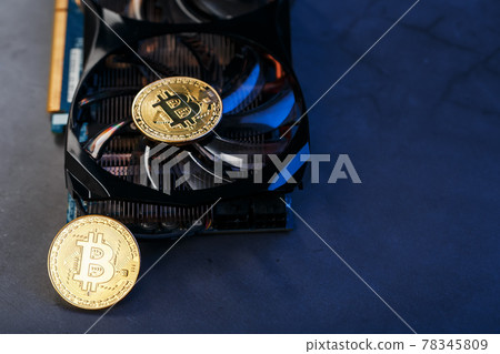 Bitcoin coin on a powerful graphics card for mining and earning cryptocurrency concept on a dark Bitcoin coin on a powerful graphics card for mining and earning cryptocurrency concept on a dark 78345809