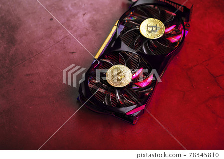 On the fans of a powerful video card, the coins of the Bitcoin cryptocurrency with a red  78345810