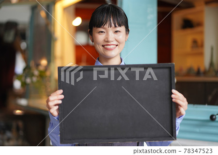 拿著在廚房車前面的女性職員一個留言板 78347523