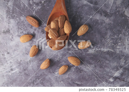 fresh almond nut on spoon on black background fresh almond nut on spoon on black background 78349325