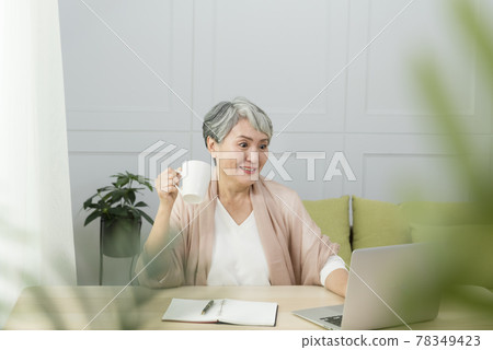 Elderly professional woman working from home during covid-19 pandemic 78349423