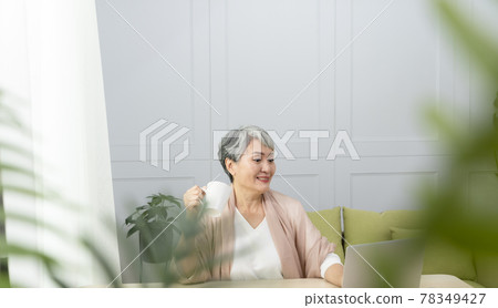Elderly professional woman working from home during covid-19 pandemic 78349427