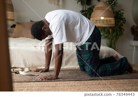 Sporty muscular young african man working out, yoga, pilates, fitness training, doing Cat Pose 78349443