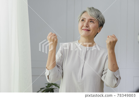 一位銀髮白髮的年長婦女在落地窗旁的肖像 78349803