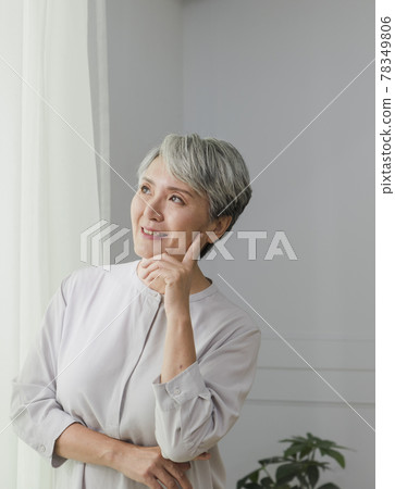一位銀髮白髮的年長婦女在落地窗旁的肖像 78349806