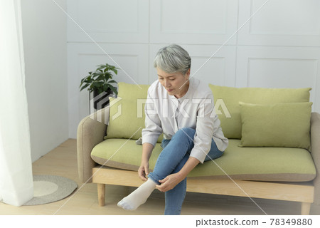 一位銀髮族年長婦女,坐在客廳的沙發上,享受悠閒自在的生活 78349880
