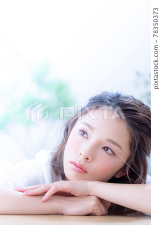 Face up of a young woman lying down on the table Face up of a young woman lying down on the table 78350373