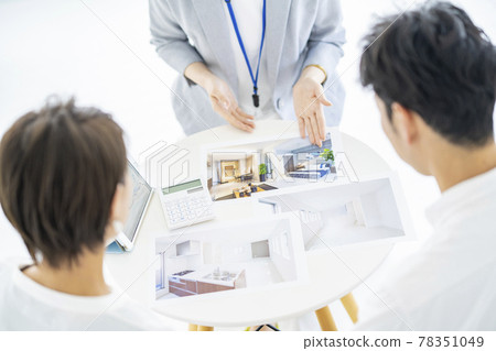 A woman in a suit who sells real estate to a couple 78351049