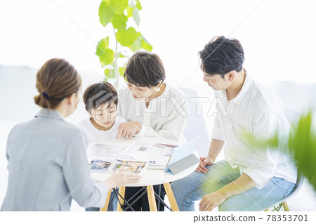 A family receiving an interior explanation from a woman in a suit 78353701