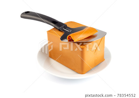 Norwegian brown cheese with cheese cutter on a plate, isolated on white background, horizontal 78354552