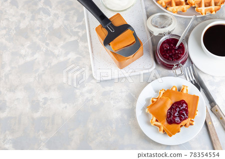 Homemade waffles with norwegian brown cheese and lingon jam, on light gray background, horizontal, copy space, top view Homemade waffles with norwegian brown cheese and lingon jam, on light gray background, horizontal, copy space, top view 78354554