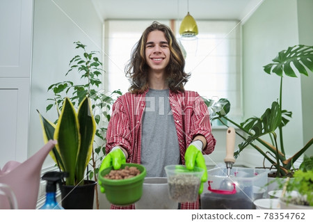 Green eco hobby of young male, teenager showing plant, soil, pot 78354762