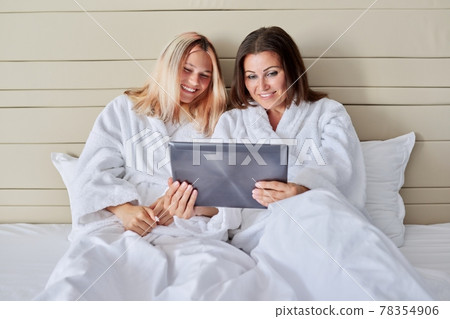 Happy laughing mother and teenage daughter with digital tablet 78354906
