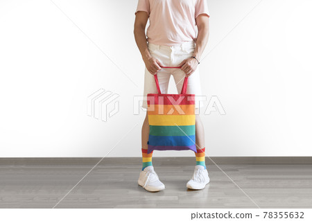 Unrecognizable young man posing dressed in socks and rainbow bag. Concept of freedom, LGBTQ+ Unrecognizable young man posing dressed in socks and rainbow bag. Concept of freedom, LGBTQ+ 78355632