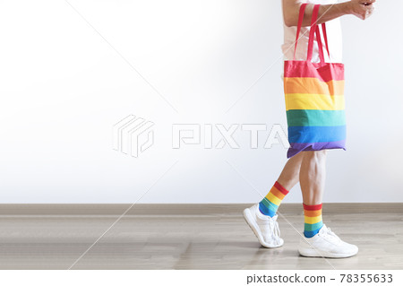 Unrecognizable young man posing dressed in socks and rainbow bag. Concept of freedom, LGBTQ+ Unrecognizable young man posing dressed in socks and rainbow bag. Concept of freedom, LGBTQ+ 78355633