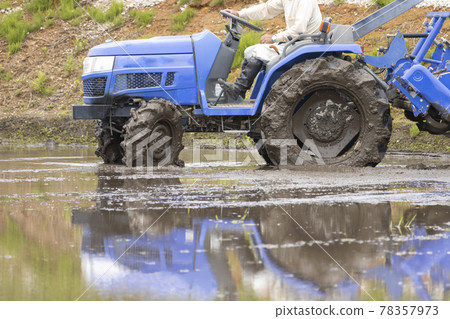 盛滿水的稻田。使用拖拉機工作 盛滿水的稻田。使用拖拉機工作 78357973