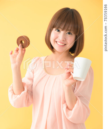 一個面帶微笑的年輕女子拿著零食和杯子 78359166