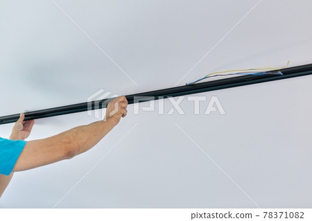 Installation of LED ceiling mounted modern track downlight. Installation of LED ceiling mounted modern track downlight. 78371082