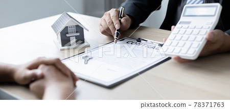 Real estate agent or sales manager talks to clients about the terms of buying a home and collateral  including a free home insurance giveaway promotion, Offerings and Services concept. 78371763