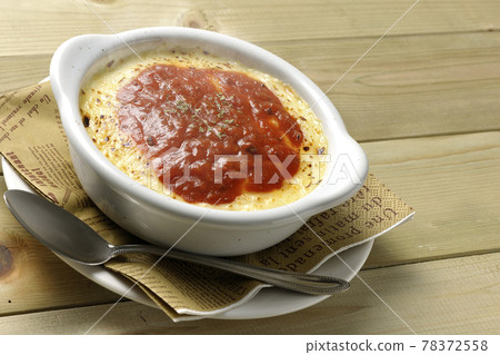 熱多利亞、烤麵包和銀勺,在餐巾紙上放上大量融化的棕色奶酪 熱多利亞、烤麵包和銀勺,在餐巾紙上放上大量融化的棕色奶酪 78372558