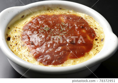 Photographed gratin, a hot doria with plenty of melted and browned cheese, on a black background 78372951