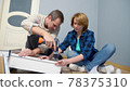 couple man and woman together install furniture in their apartment. 78375310
