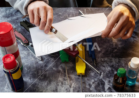 The master cuts the paper with a knife. Checking the sharpness of the knife. Knives and whetstones. 78375633