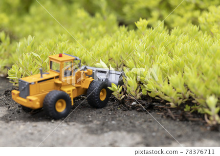 Wheel loader of a miniature car that destroys a colony of Sedum sarmentum Wheel loader of a miniature car that destroys a colony of Sedum sarmentum 78376711