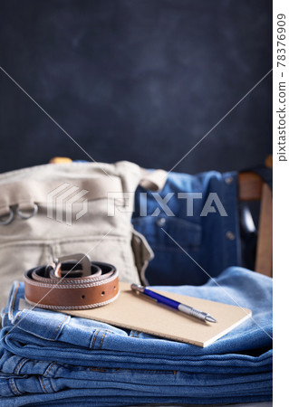 Denim jeans at wooden chair. Stack of jeans and belt Denim jeans at wooden chair. Stack of jeans and belt 78376909