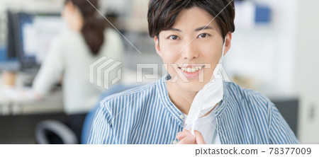 一個休閒風格的年輕商人,他摘下面具,對著辦公室橫幅大小微笑 一個休閒風格的年輕商人,他摘下面具,對著辦公室橫幅大小微笑 78377009