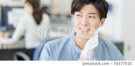 A casual style young businessman who removes his mask and smiles at the office Banner size A casual style young businessman who removes his mask and smiles at the office Banner size 78377010