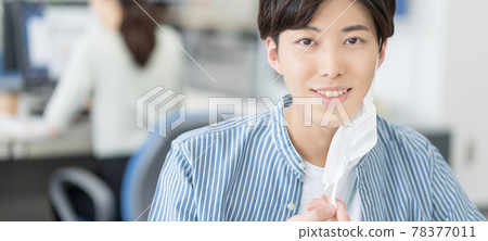 A casual style young businessman who removes his mask and smiles at the office Banner size A casual style young businessman who removes his mask and smiles at the office Banner size 78377011