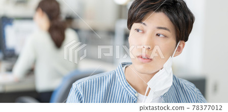 A casual style young businessman who removes his mask and smiles at the office Banner size 78377012