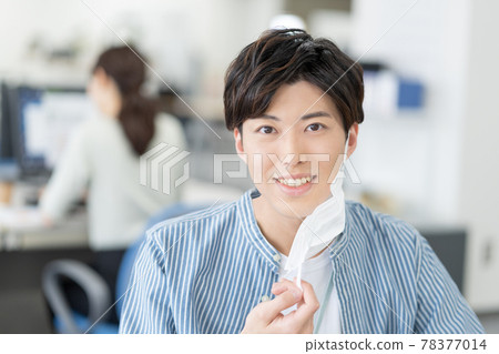 A casual-style young businessman who removes his mask and smiles in the office A casual-style young businessman who removes his mask and smiles in the office 78377014