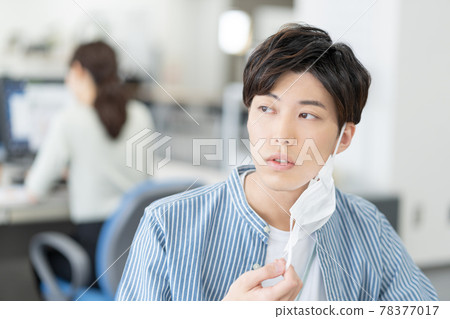 A casual-style young businessman who removes his mask and smiles in the office A casual-style young businessman who removes his mask and smiles in the office 78377017