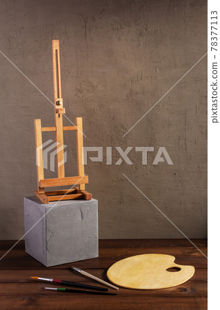 Paint brush and easal with palette on wooden table. Paintbrush and art still life Paint brush and easal with palette on wooden table. Paintbrush and art still life 78377113