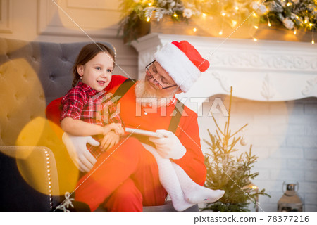 Santa Claus and child at home against Christmas tree. Family holiday concept Santa Claus and child at home against Christmas tree. Family holiday concept 78377216