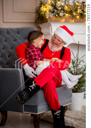Santa Claus and child at home against Christmas tree. Family holiday concept Santa Claus and child at home against Christmas tree. Family holiday concept 78377219