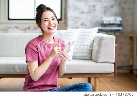 年輕女子在客廳看智慧型手機 78378705