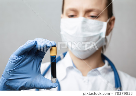 Doctor holding test tube with blue fluid Doctor holding test tube with blue fluid 78379833
