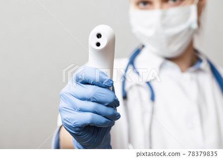 Doctor pointing infrared thermometer gun to check body temperature epidemic virus outbreak concept Doctor pointing infrared thermometer gun to check body temperature epidemic virus outbreak concept 78379835