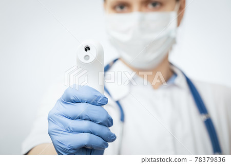 Doctor pointing infrared thermometer gun to check body temperature epidemic virus outbreak concept Doctor pointing infrared thermometer gun to check body temperature epidemic virus outbreak concept 78379836