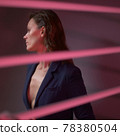 beautiful woman in a jacket worn on a naked body. gray background with red backlight 78380504